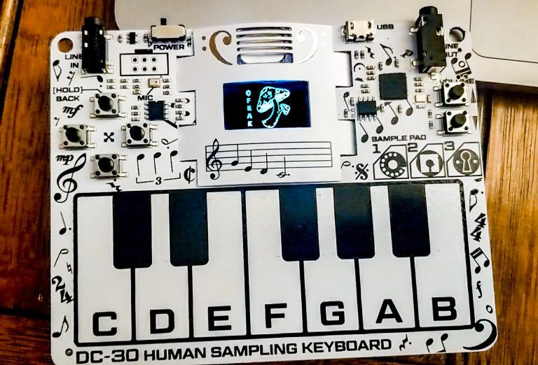 DEF CON 30 human sampling keyboard badge on a wooden table
